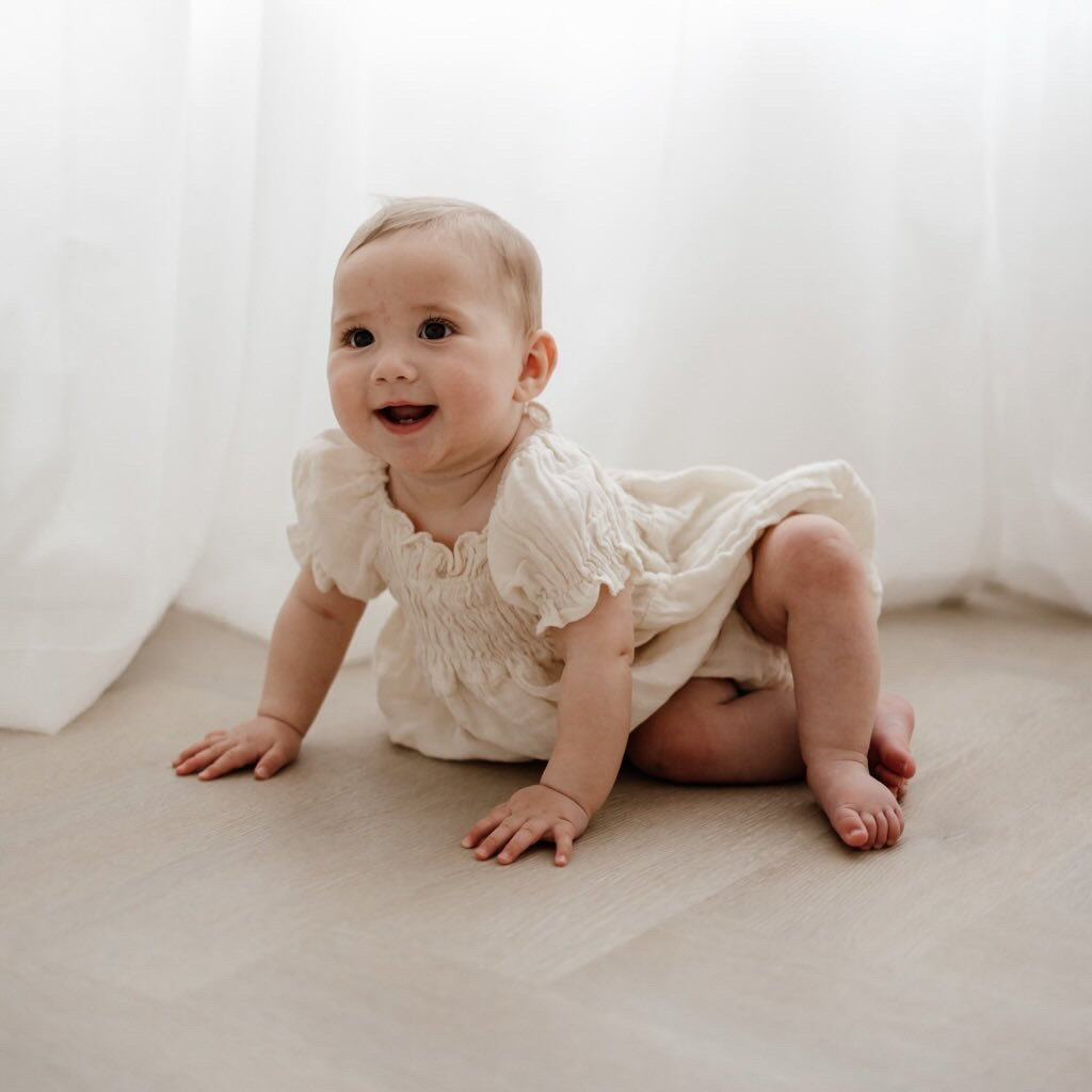 Baby crawling on hybrid herringbone flooring in a bright family home